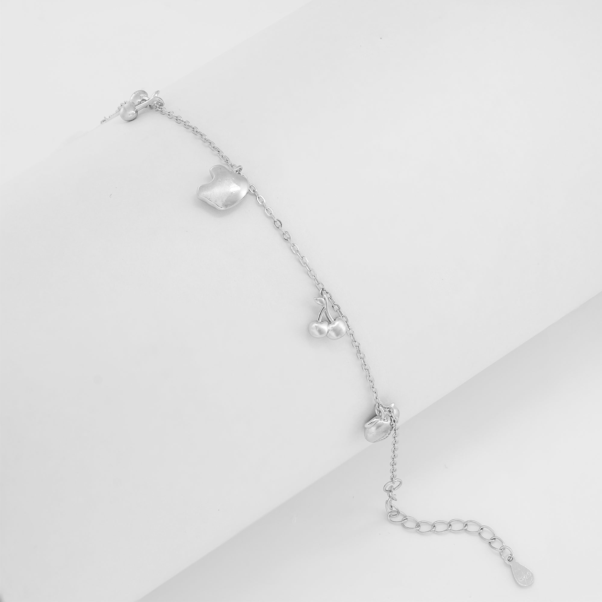 Close-up of the Apple-Cherry charm bracelet crafted in 925 sterling silver featuring apple, cherry, and playful fruit charms on a delicate silver-toned chain.