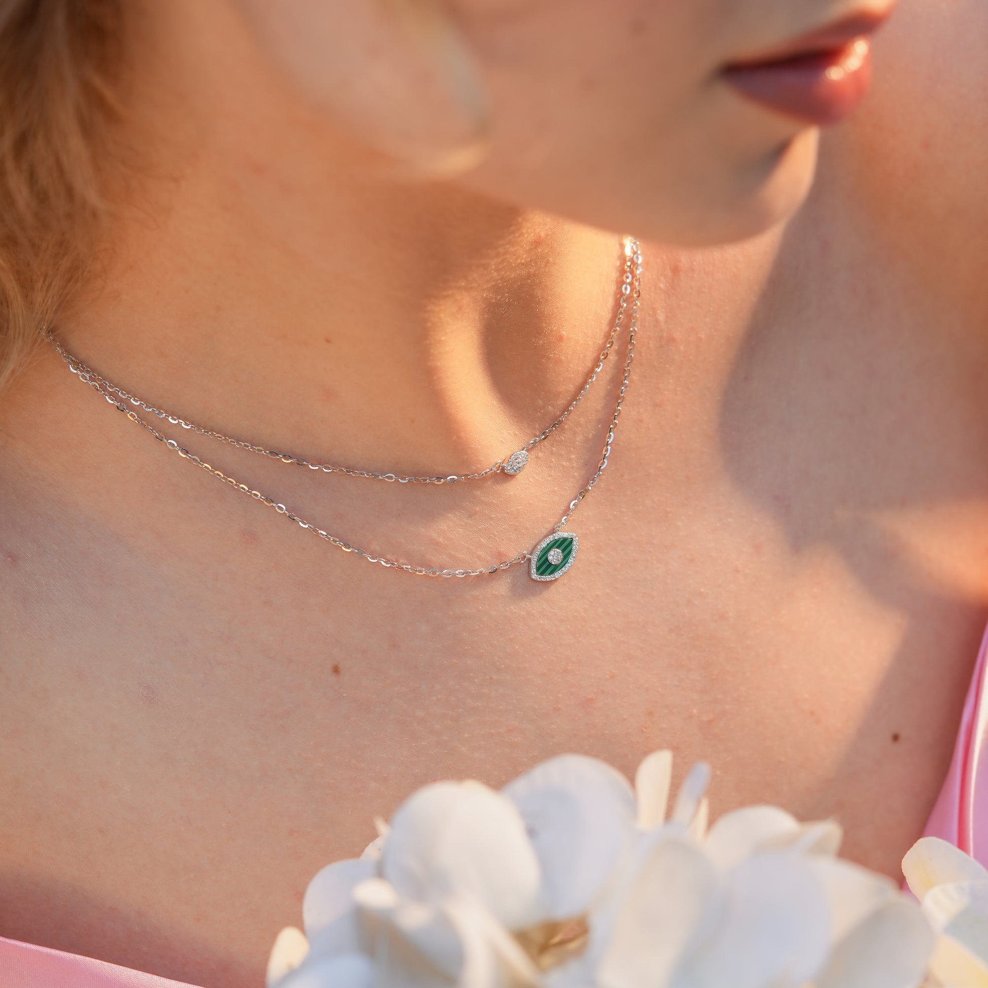 Woman wearing the Emerald Marquise Layered Necklace with a marquise green enamel pendant, styled with an open neckline for a chic layered look.
