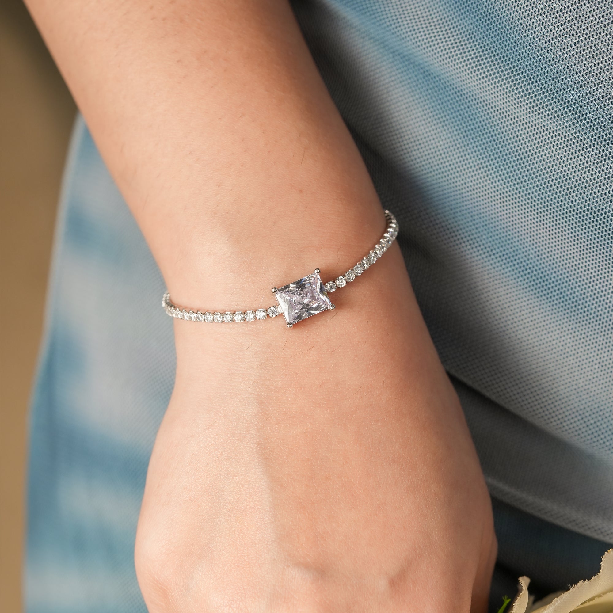 Woman wearing IHA Fine Jewellery’s silver bracelet with princess-cut stone – elegant minimal look