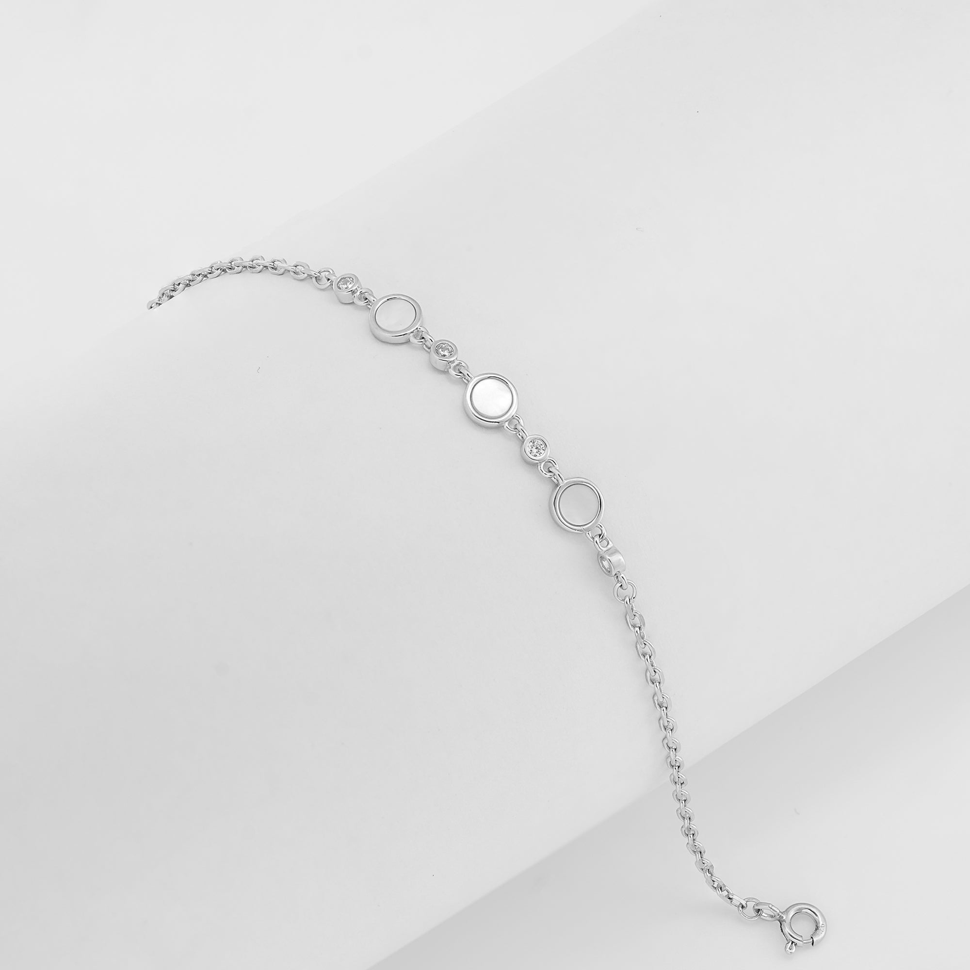 Silver bracelet with mother-of-pearl and cubic zirconia accents on a white background