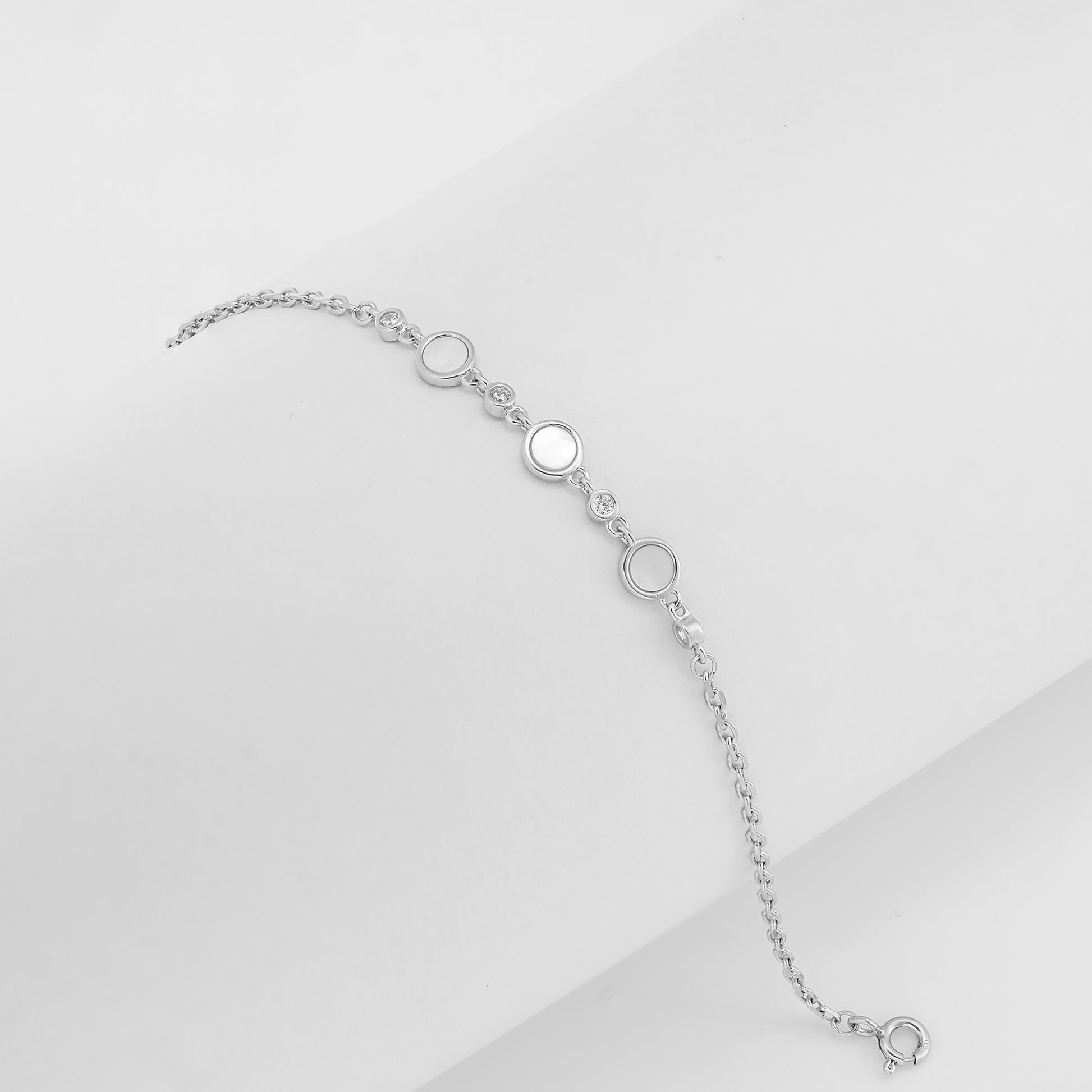Silver bracelet with mother-of-pearl and cubic zirconia accents on a white background