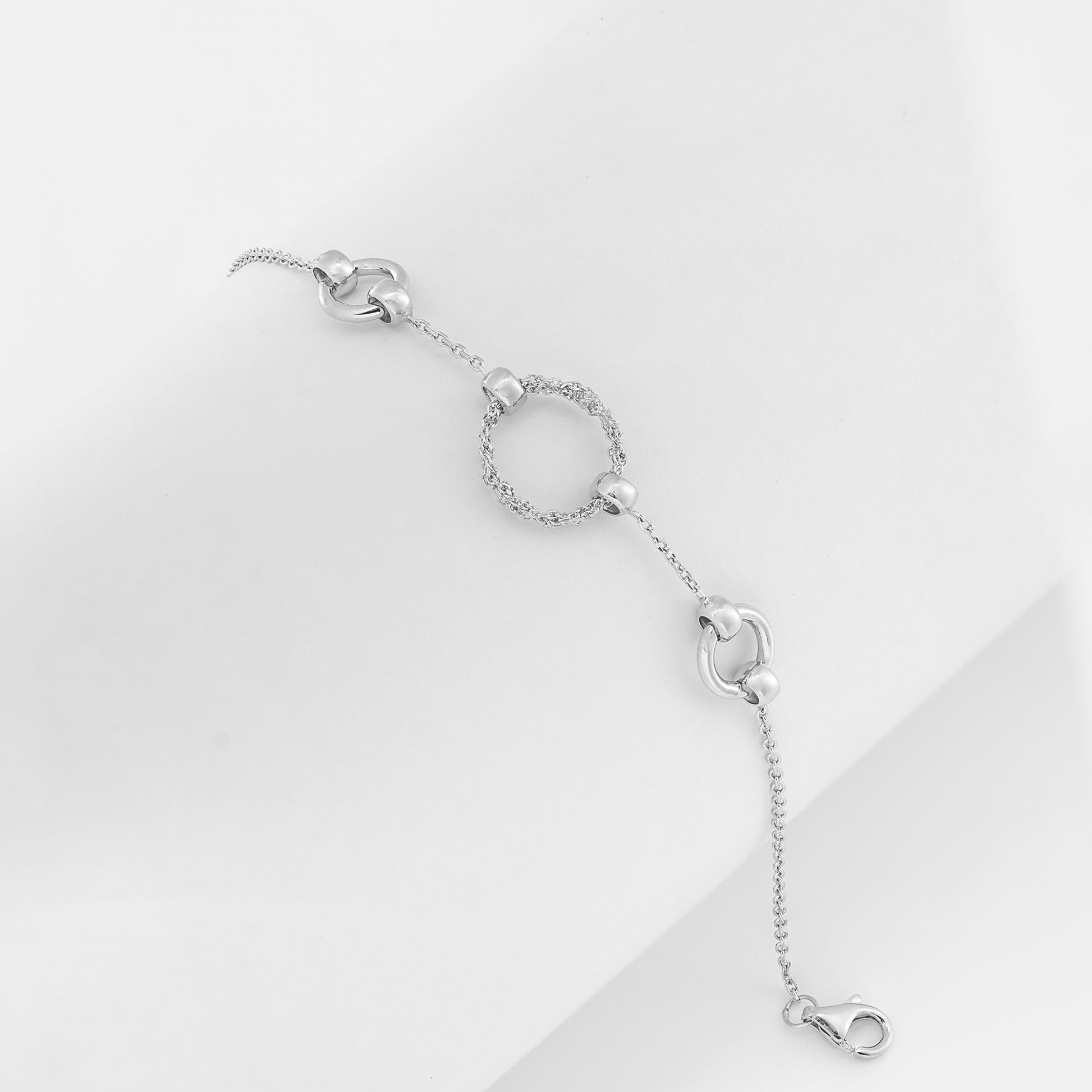 Elegant silver bracelet with cubic zirconia and polished circular links on a clean background.