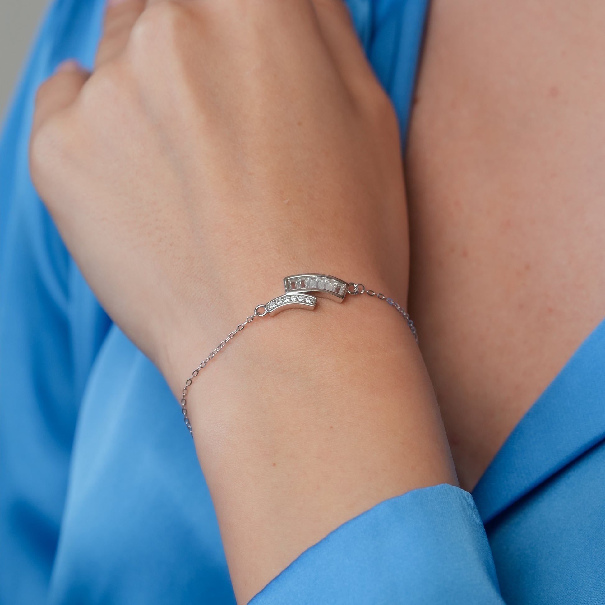 Woman wearing the Dual Curve Spark Bracelet on wrist, paired with formal attire, showcasing modern elegance in sterling silver.