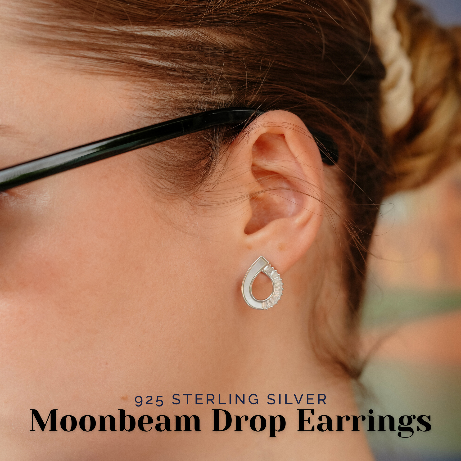 Close-up of a woman wearing Moonbeam Drop Earrings, showcasing the shine of the pearl and CZ stones.