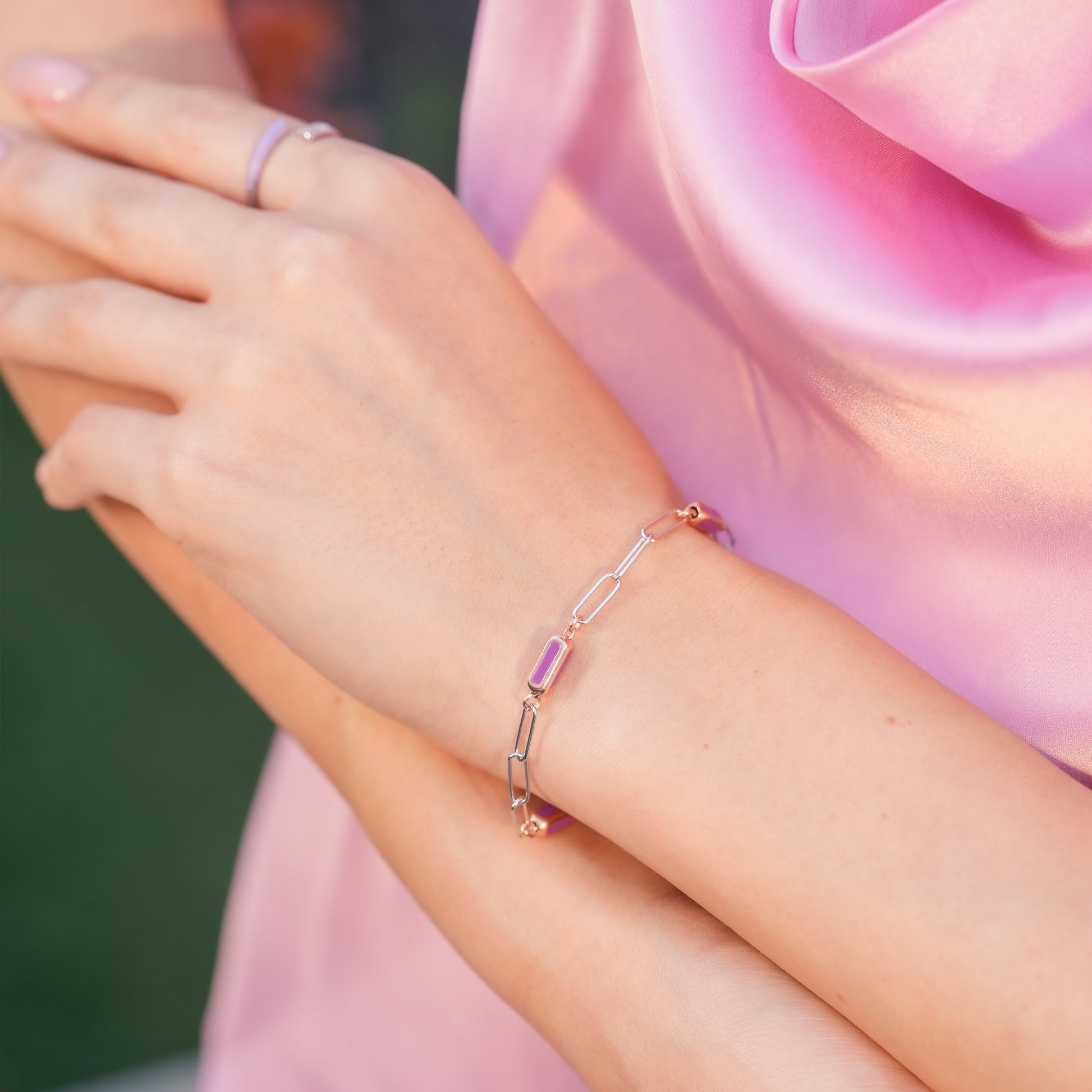 Bold enamel bracelet styled on woman’s wrist with chic city-inspired outfit.