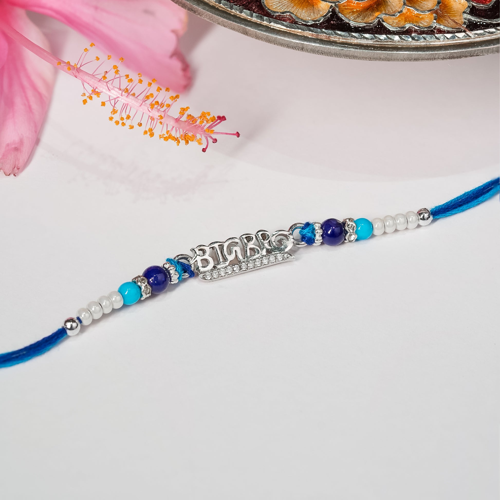 Big Bro Rakhi crafted in sterling silver on a charcoal thread, displayed on white background.
