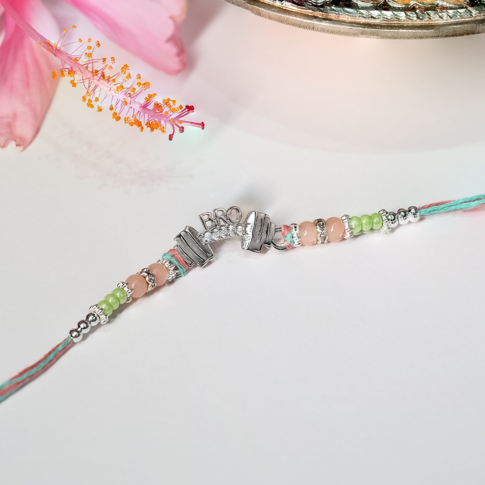 925 silver rakhi featuring dumbbell and Bro charm on dark sporty thread, displayed on plain background.