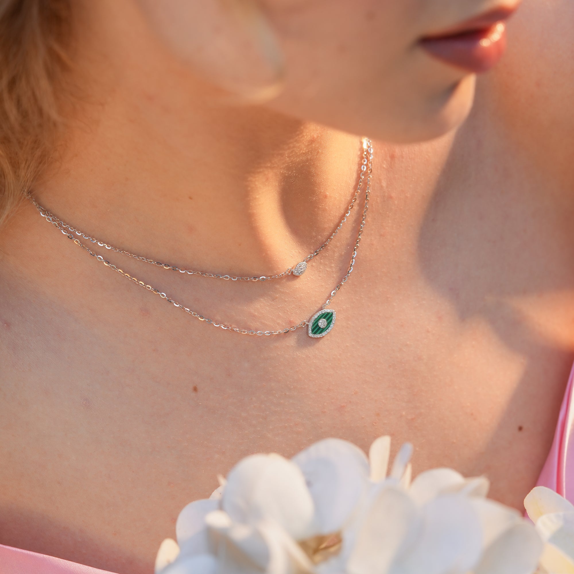 Woman wearing the Emerald Marquise Layered Necklace with a marquise green enamel pendant, styled with an open neckline for a chic layered look.