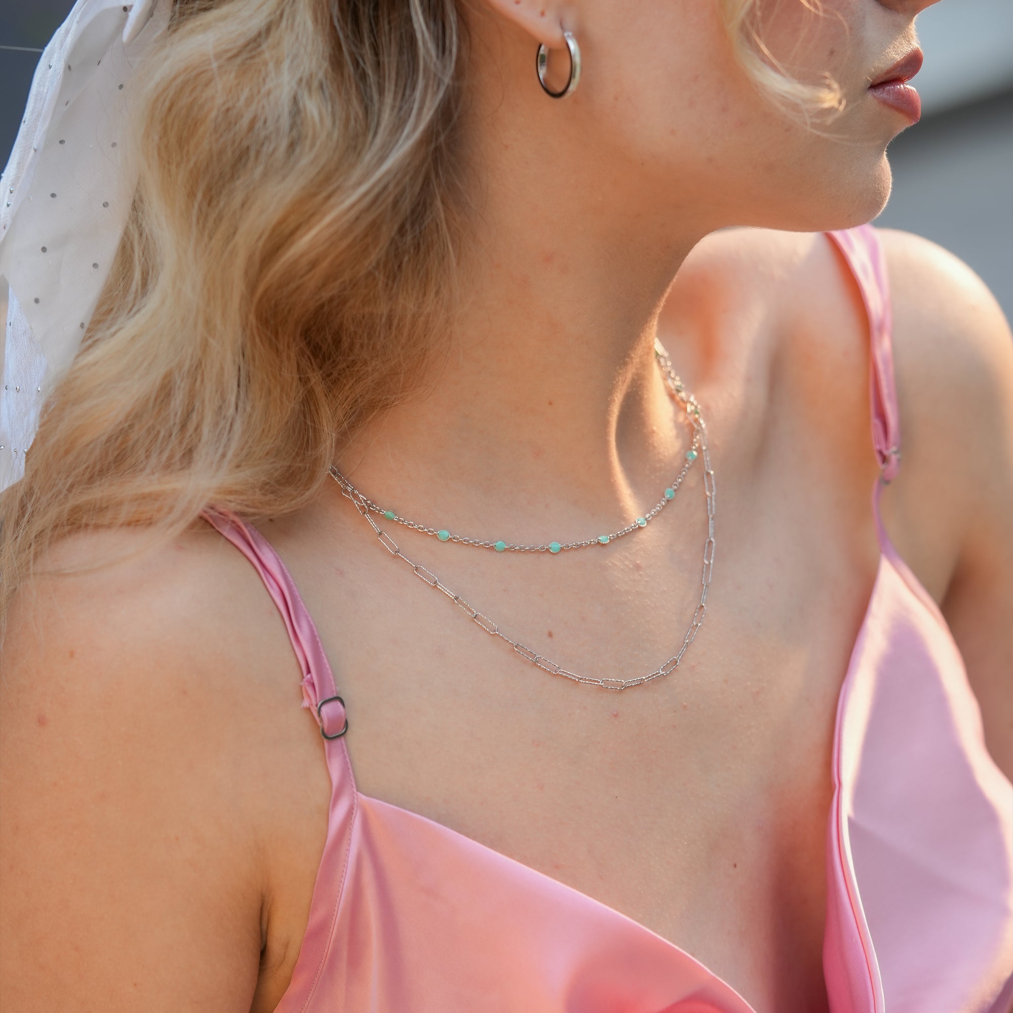 Woman wearing the Meadow Mist Silver Chain layered necklace, styled with a soft pastel top for an effortlessly chic look.
