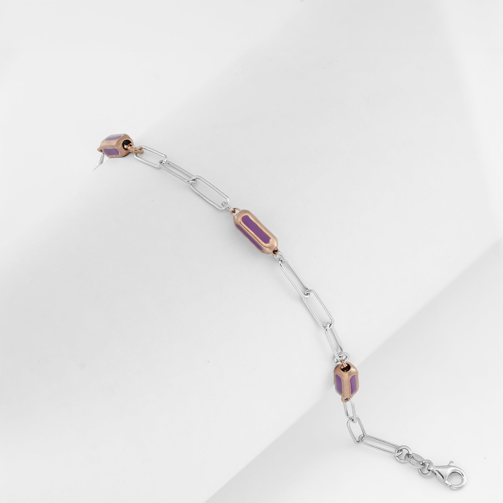 Dual-tone chain bracelet with glossy violet-pink enamel on a clean backdrop.