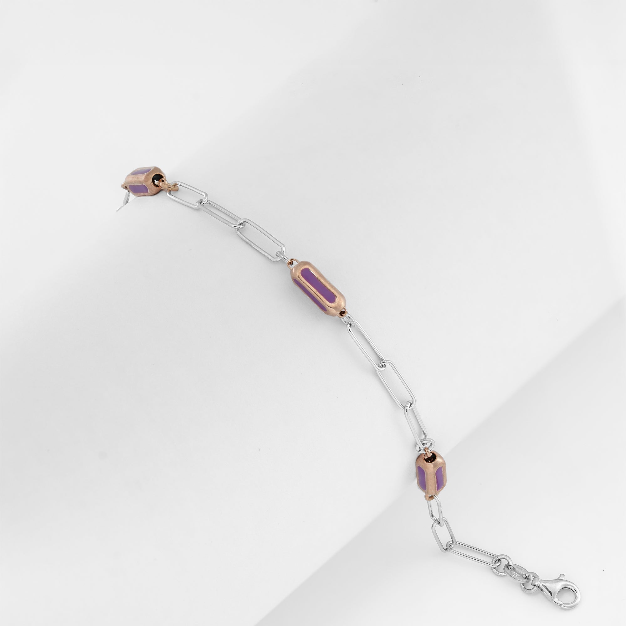 Dual-tone chain bracelet with glossy violet-pink enamel on a clean backdrop.