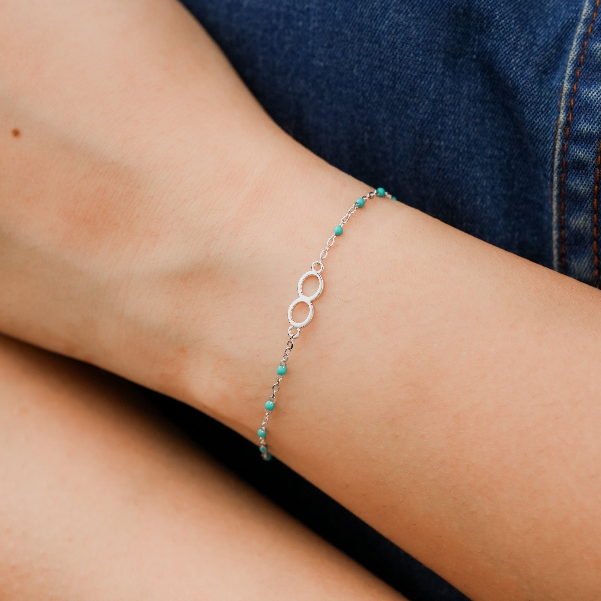  Model showcasing the Infinity Embrace Bracelet styled with a neutral outfit for a minimal look.


