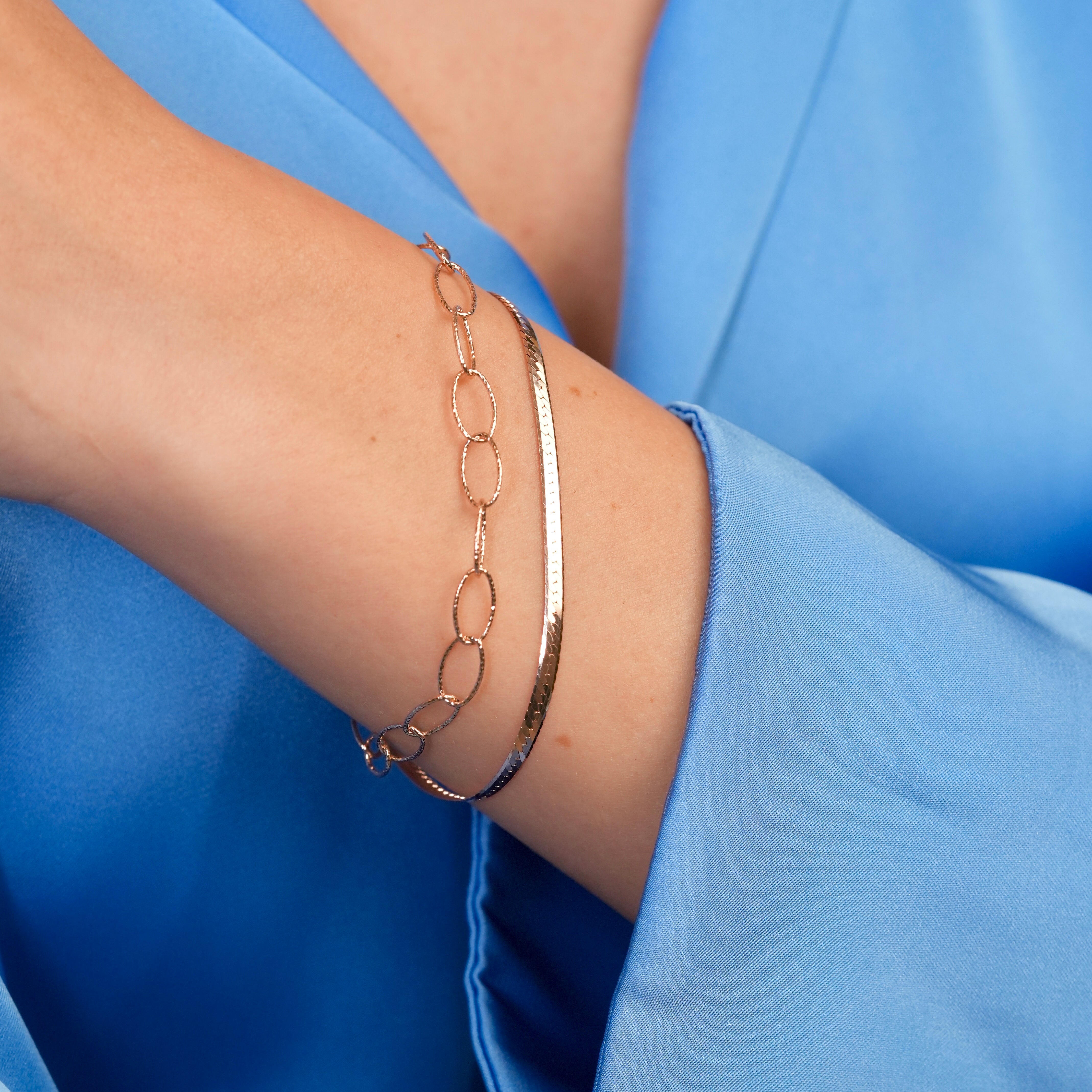 Stylish rose gold bracelet on model’s wrist, paired with a neutral-toned outfit.